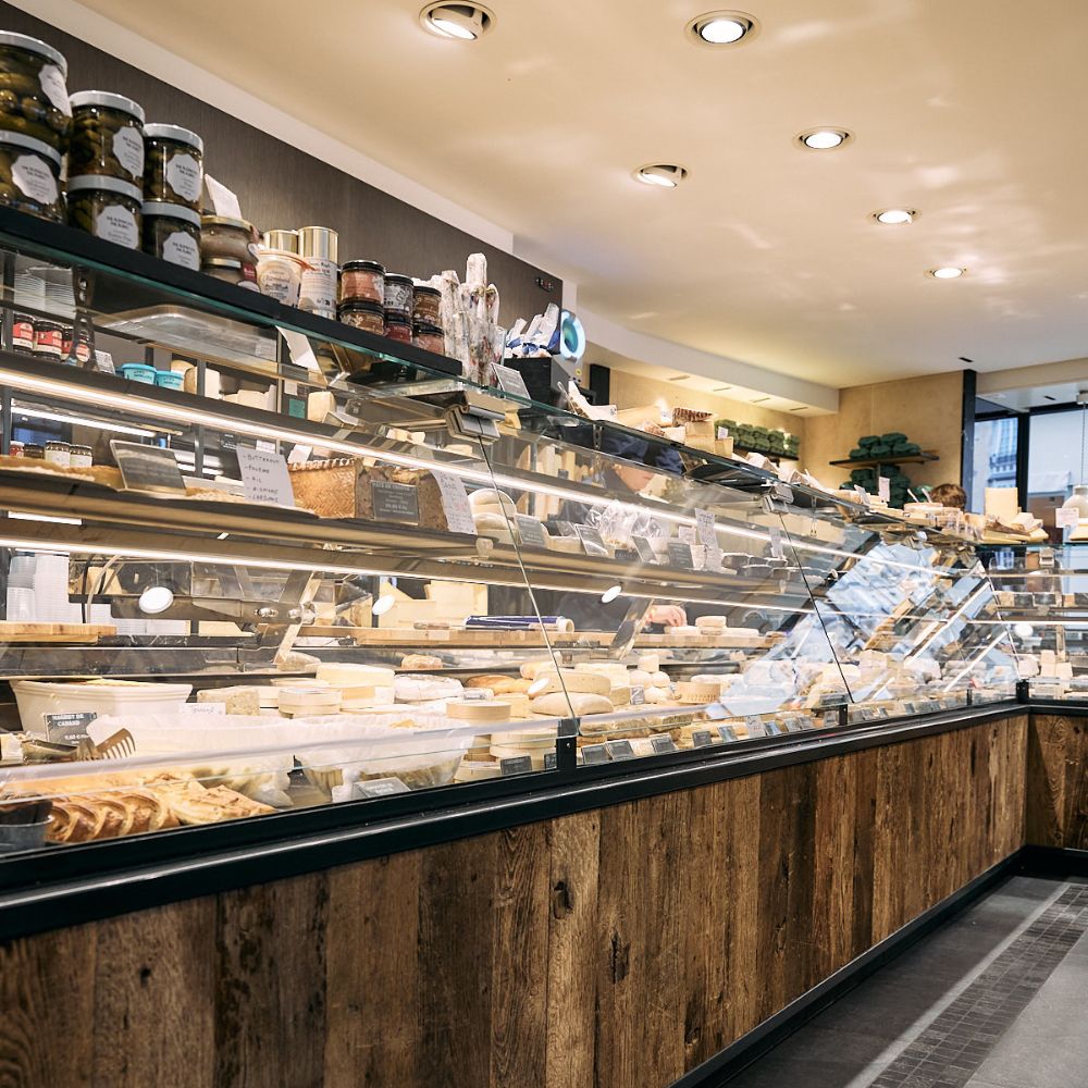 Une vitrine de fromagerie avec des fromages